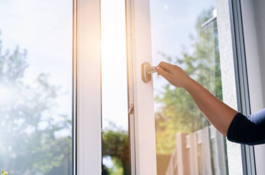 Ventana de PVC blanca abierta hacia el exterior en una vivienda luminosa