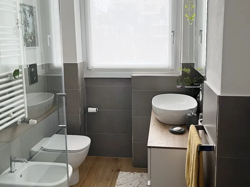 Baño con plato de ducha y mampara de cristal tras sustituir la bañera