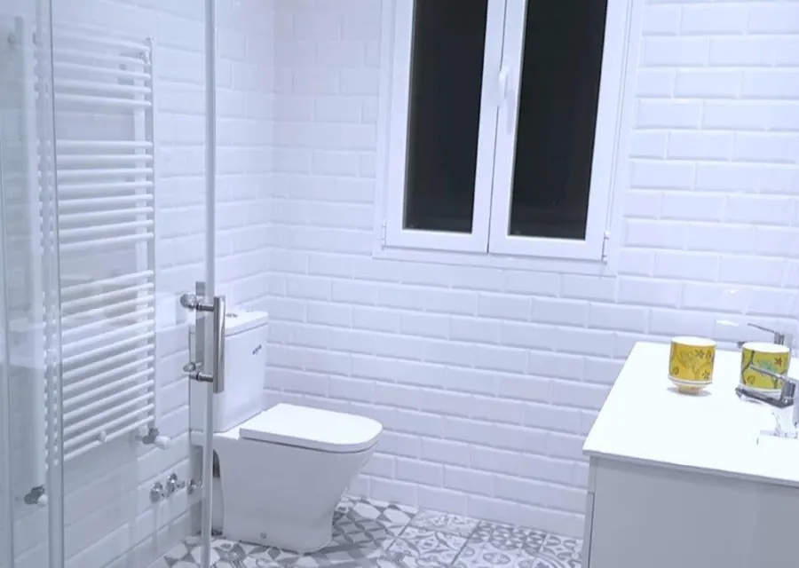 Baño reformado en Algorta (Getxo) con azulejo metro blanco y suelo hidráulico