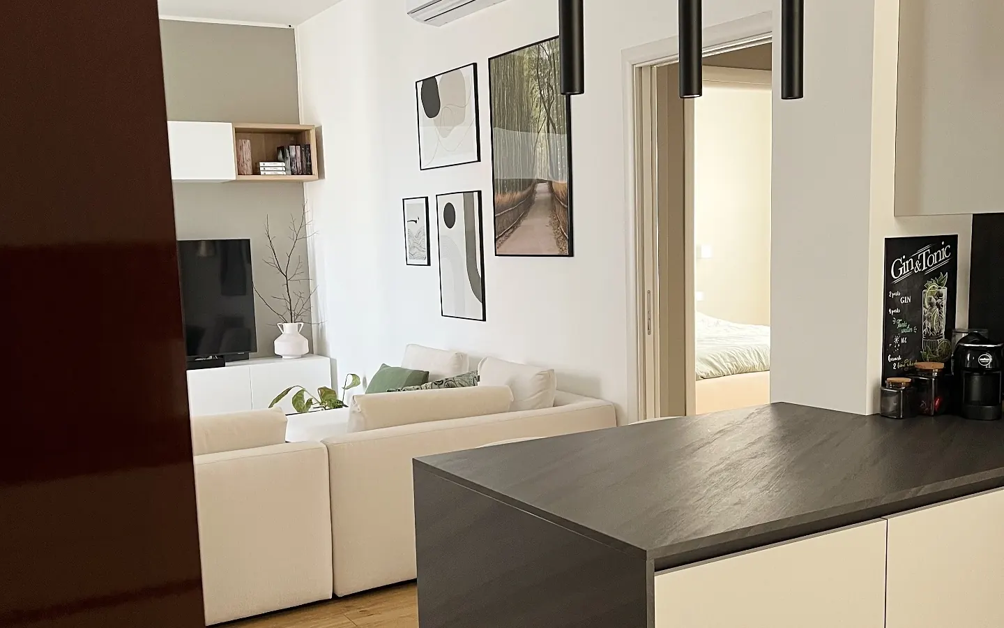 Cocina abierta al salón con isla y suelo de madera tras una reforma integral